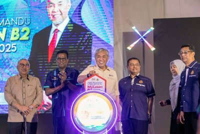 Ahmad Zahid (tiga dari kiri) menyempurnakan gimik perasmian pada Majlis Penyerahan Lesen Memandu Program MyLesen B2 Peringkat Negeri Perak Tahun 2025 di Kompleks UMNO Bagan Datuk hari ini. Foto Bernama