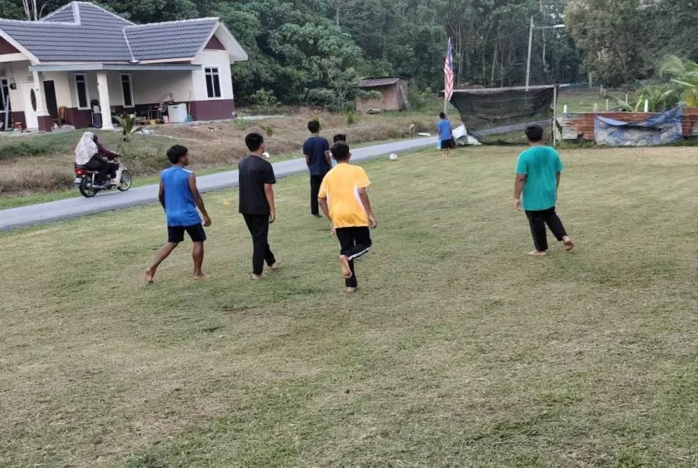 Aktiviti bermain bola sepak di halaman rumah ketua kampung. 