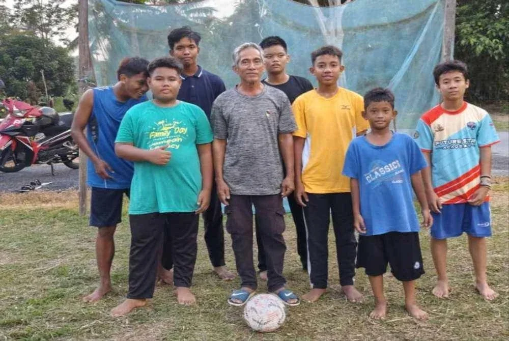 Aktiviti bermain bola sepak di halaman rumah ketua kampung. 
