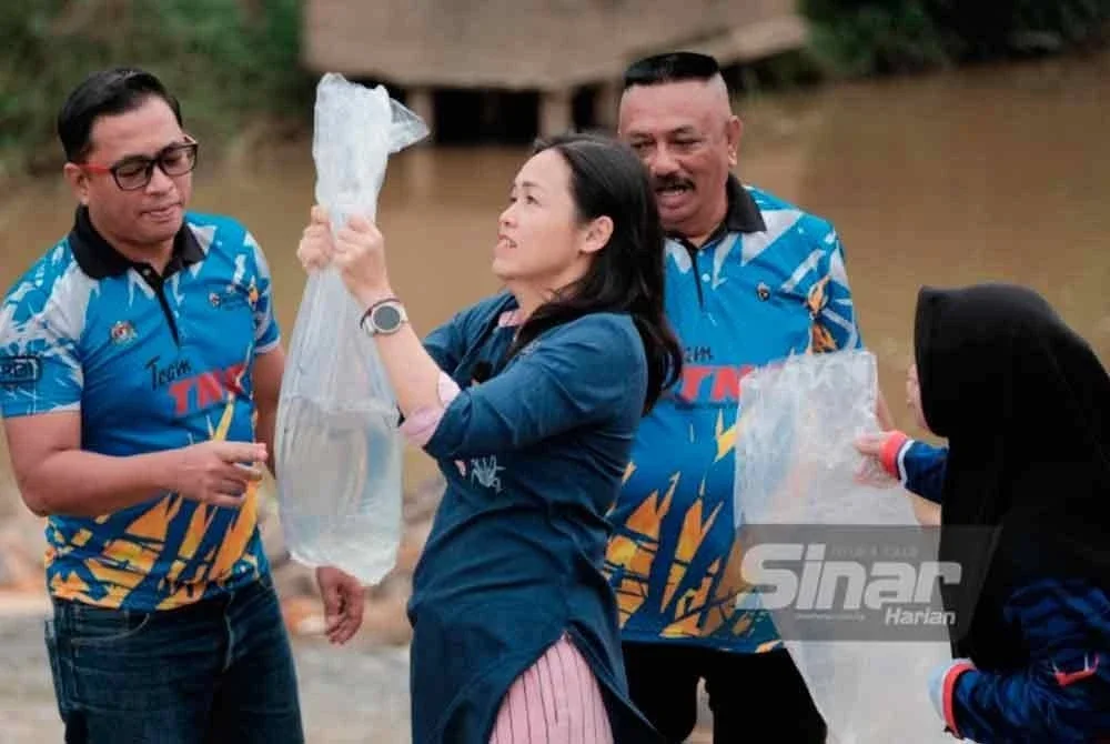 Nie Ching menyempurnakan pelepasan ikan tilapia dan lampam sebagai gimik pelancaran program.