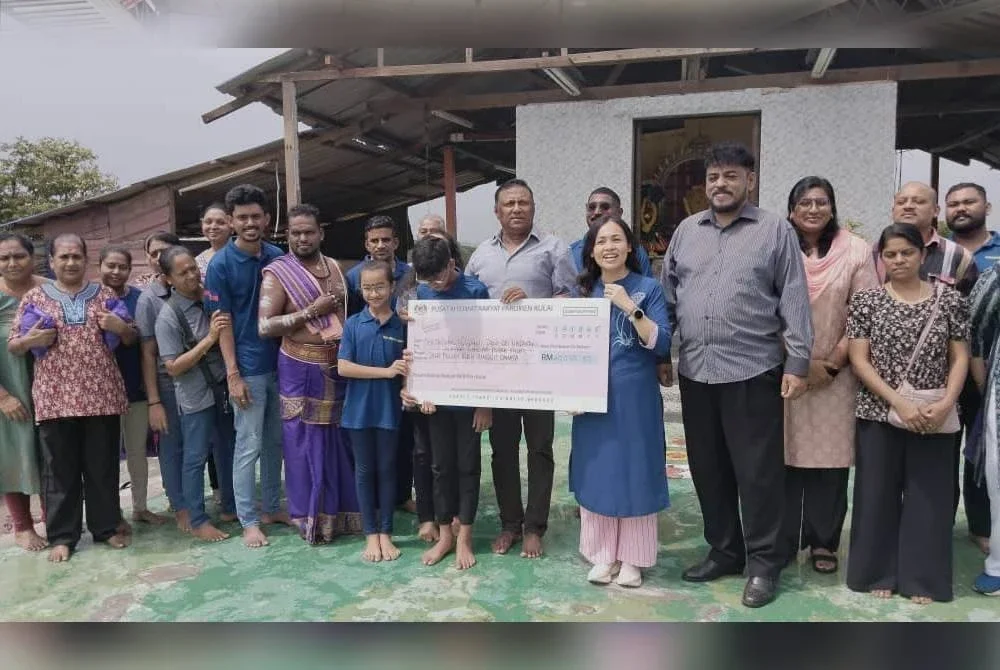 Nie Ching (lima, kanan) ketika menyerahkan sumbangan kepada Kuil Sri Nagakanni, Bandar Putra Kulai pada Ahad.