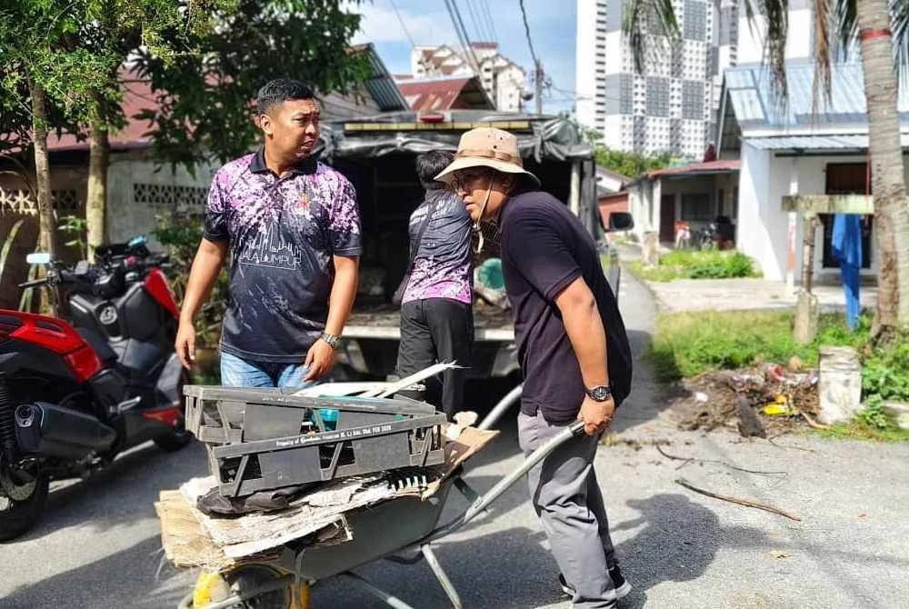 Peserta melakukan kerja-kerja pembersihan serta cantasan pokok bagi menghapuskan potensi tempat pembiakan Aedes.- Foto DBKL