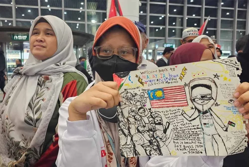 Khaleda Farihin menunjukkan lukisan yang dilukis khas untuk Dr Fauziah.