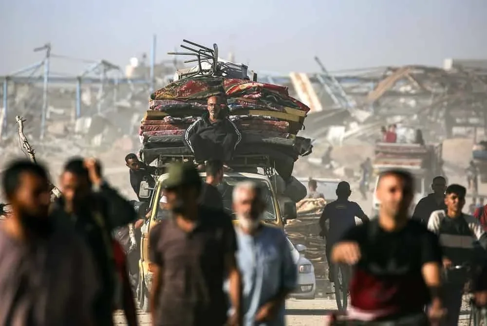 Penduduk Palestin dalam perjalanan menuju ke Bandar Gaza melalui koridor Netzarim dari Nuseirat di tengah Semenanjung Gaza selepas Israel mengisytiharkan gencatan senjata di Gaza dan mula menarik balik pasukannya pada 10 Oktober (Foto AFP)