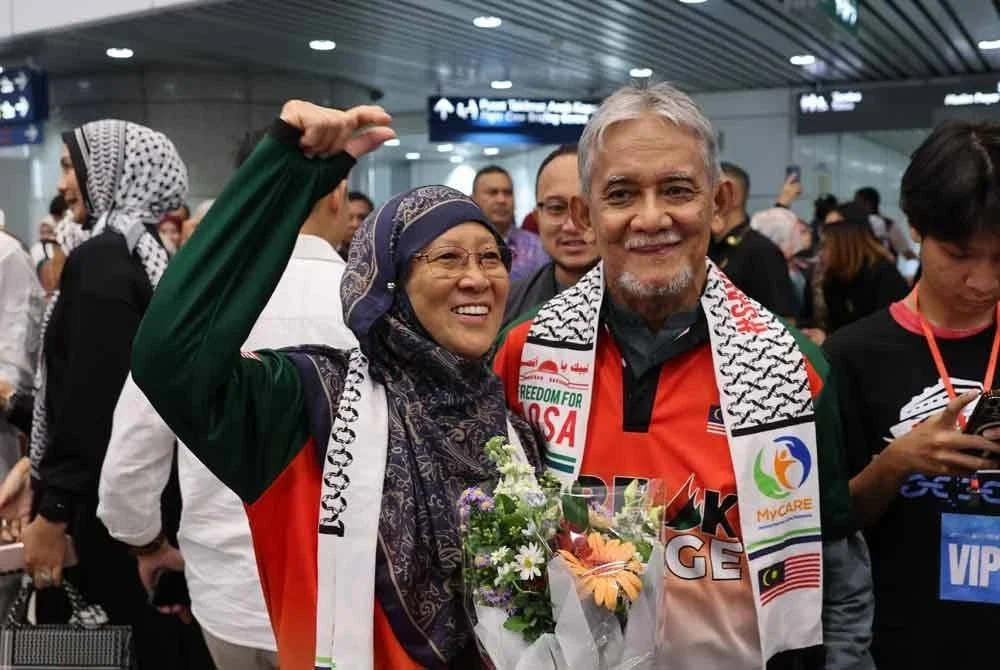 Dr Mohd Alauddin (tengah) bersama isteri, Dr Fauziah (kiri) sejurus tiba di KLIA Terminal 1 hari ini. - Foto: Bernama