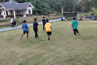 Aktiviti bermain bola sepak di halaman rumah ketua kampung. 