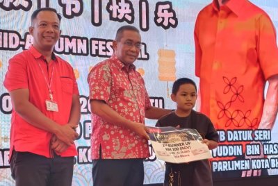Takiyuddin (tengah) menyampaikan hadiah kepada pemenang pada Sambutan Malam Kebudayaan Perayaan Pesta Tanglung di Kota Bharu pada Sabtu.