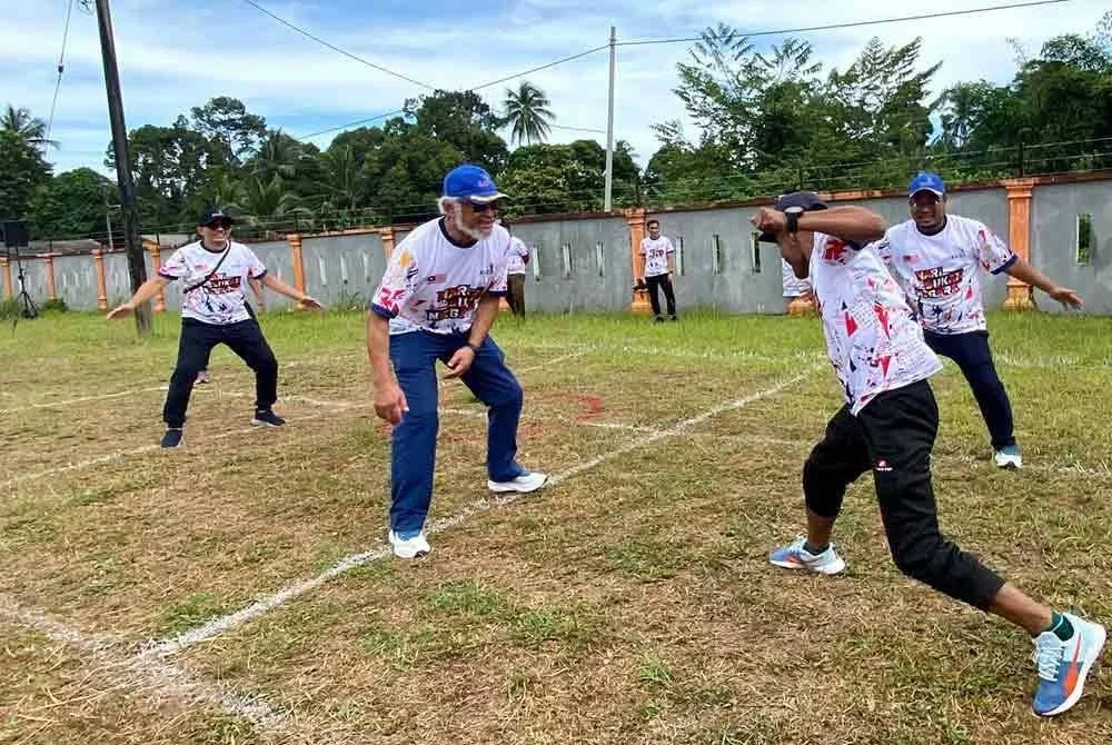 Khalid (kiri) turut sama menyertai permainan galah panjang sempena sambutan Hari Sukan Negara 2025 Peringkat KADA yang diadakan di Pusat Latihan Pertanian (PLP) Jambu Merah di Kota Bharu pada Isnin. Foto: SINAR HARIAN/HAZELEN LIANA KAMARUDIN