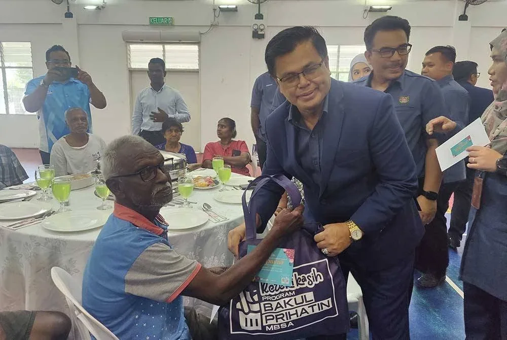 Mohd Fauzi (tengah) menyampaikan sumbangan kepada salah seorang penerima pada Program Prihatin MBSA sempena Perayaan Deepavali di Dewan Aster MBSA, Seksyen 32, Shah Alam pada Isnin.