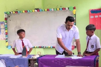 Muchamad Viki Adi Purba sedang mengajar anak murid seterika pakaian. - Agensi