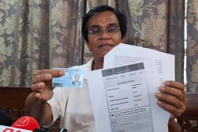 Mohd Rawi menunjukkan MyKad baharu dan salinan semakan bantuan SARA dalam sidang akhbar pada Isnin.