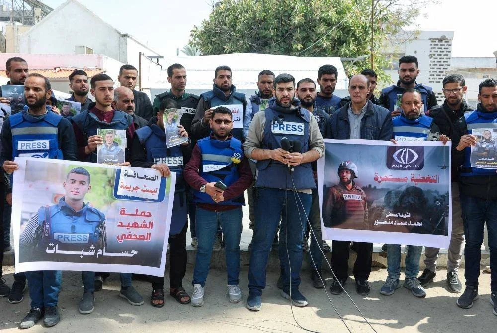 Wartawan Palestin mengangkat plakad membantah pembunuhan rakan sejawatan mereka, Hussam Shabat dan Muhammad Mansour dalam serangan Israel di Bandar Gaza. AFP