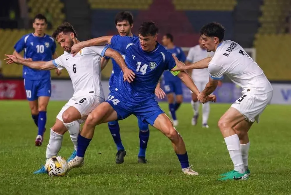 Ketua Pasukan Uzbekistan, Shomurodov Eldor (tengah) diasak dua pemain Uruguay pada perlawanan Bola Sepak Stars of Uruguay, Global Friendly In Malaysia di Stadium Hang Jebat, Krubong pada Isnin. Foto Bernama