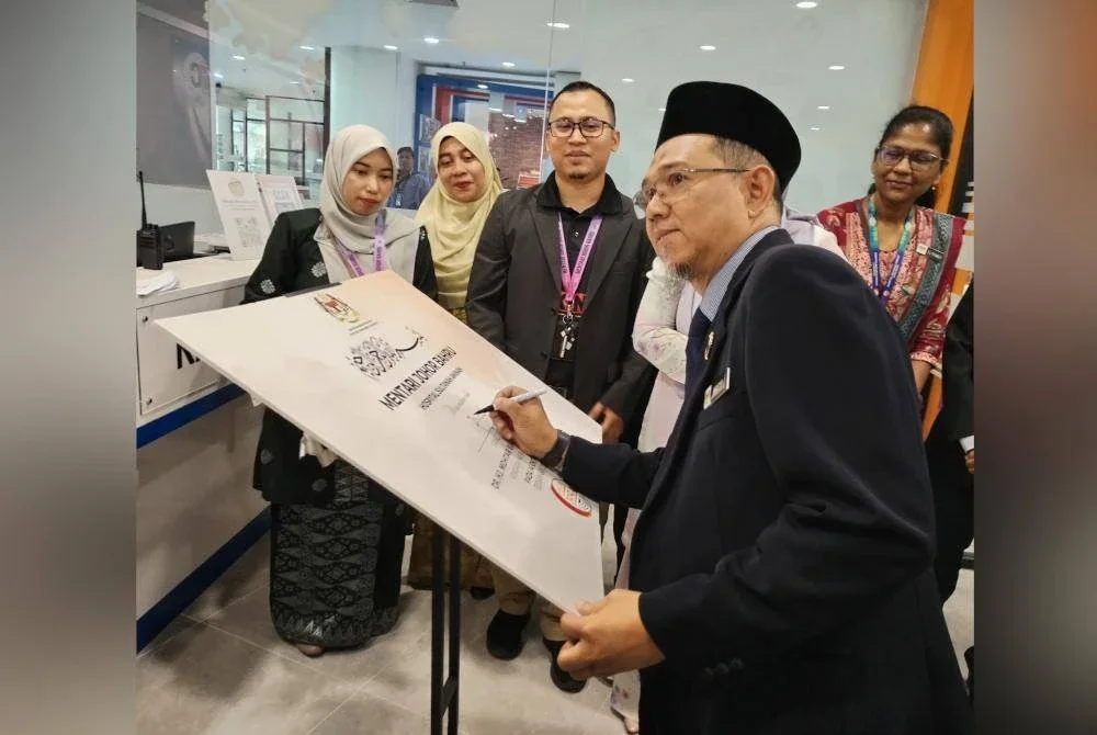 Mokhtar (kanan) menandatangani plak perasmian Mentari Johor Bahru sempena Sambutan Hari Kesihatan Mental Sedunia 2025 pada Selasa.