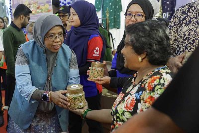 Timbalan Menteri Perumahan dan Kerajaan Tempatan Datuk Aiman Athirah Sabu menyampaikan muruku secara percuma kepada orang ramai pada Program Libat Urus Deepavali Lestari 2025 di Tapak Parkir Stadium Bukit Jalil. Foto Bernama