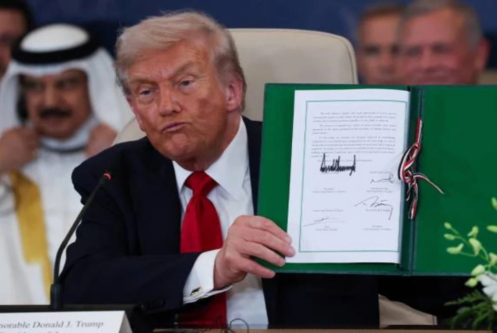 Trump memegang dokumen yang ditandatangani semasa sidang kemuncak bagi menyokong usaha menamatkan perang Israel-Hamas susulan kejayaan mencapai perjanjian gencatan senjata di Sharm El Sheikh, Mesir. Foto AP