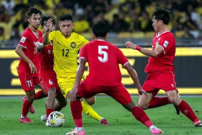 Arif Aiman cuba melepasi pemain Laos pada perlawanan Kumpulan F Kelayakan Piala Asia 2027 antara Malaysia menentang Laos di Stadium Nasional Bukit Jalil pada Selasa. Foto Bernama