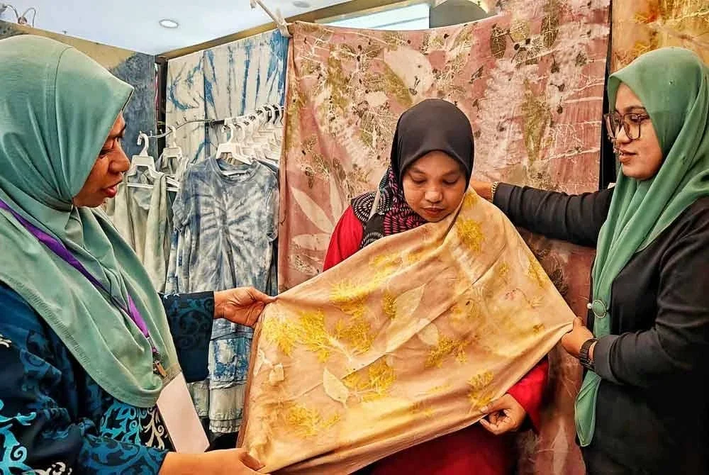 Wan Nor Azizah menunjukkan kain gang dihasilkan daripada teknik cetakan kreatif atau ecoprint itu dipelajarinya sekali gus menjadi sumber pendapatan sampingan buatnya.