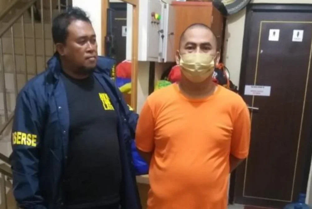 Suspek (kanan) menyerah diri kepada pihak polis.-Agensi