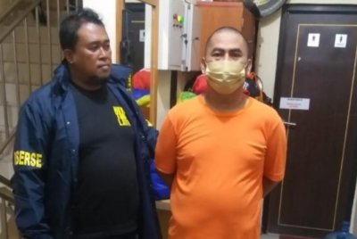 Suspek (kanan) menyerah diri kepada pihak polis.-Agensi