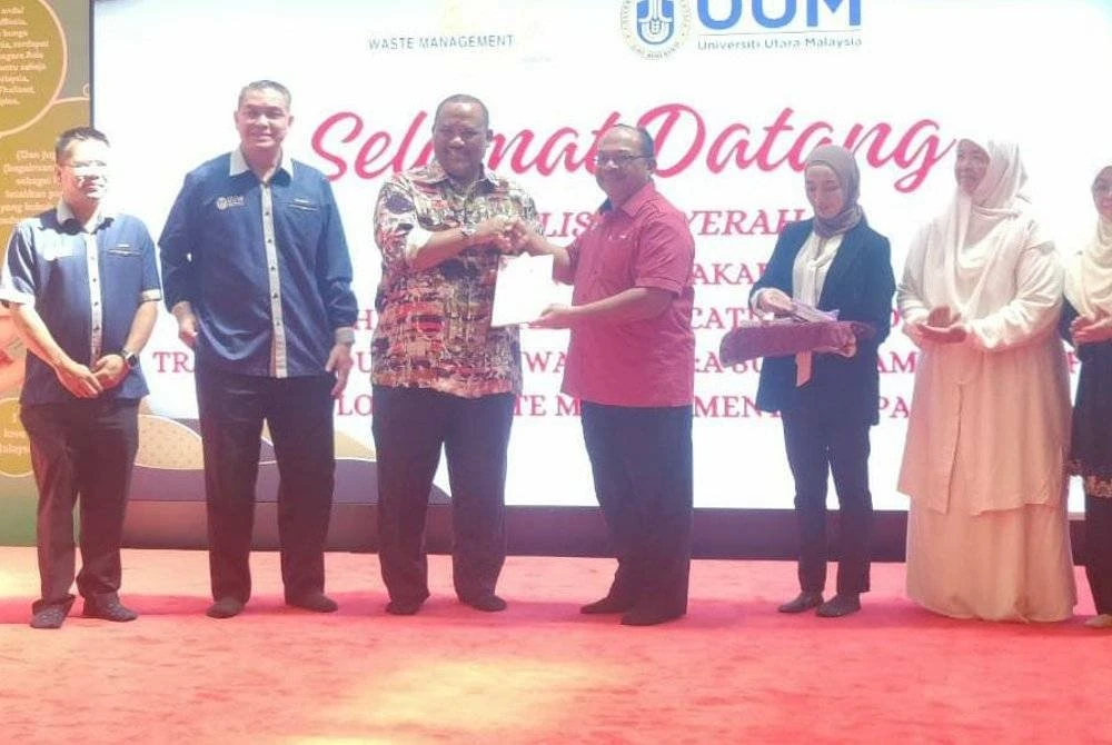 Naib Canselor Universiti Utara Malaysia, Profesor Datuk Dr Mohd Foad Sakdan (empat dari kanan) menyerahkan laporan kajian kepada Ramli (tiga dari kiri) pada Jumaat.