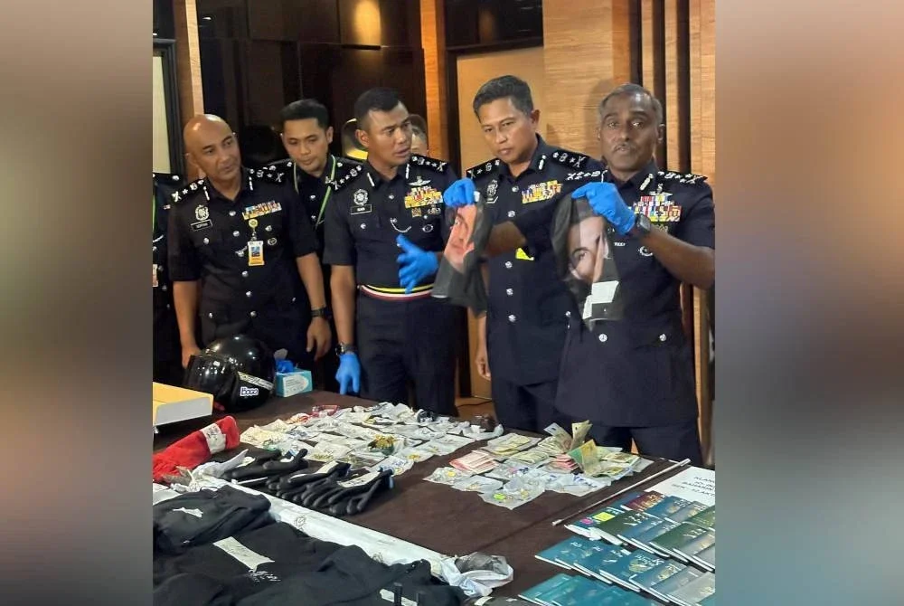 Kumar (kanan) menunjukkan antara topeng muka yang dirampas membabitkan Geng Latin.