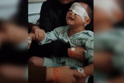 Seorang kanak-kanak buta sebelah mata selepas gurunya menyapu lemak babi pada luka. Foto Sing Tao Daily