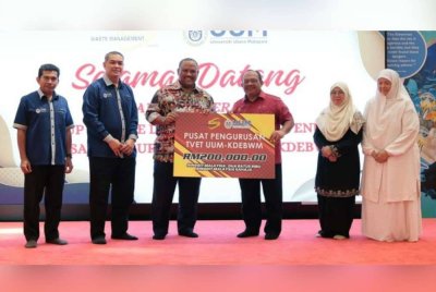 Ramli (tiga dari kiri) menyerahkan replika cek kepada Mohd Foad (tiga dari kanan) pada Majlis Penyerahan Laporan Kajian, Penyerahan Dana Sumbangan dan Pelancaran Sistem Pengurusan TVET UUM-KDEBWM pada Jumaat.