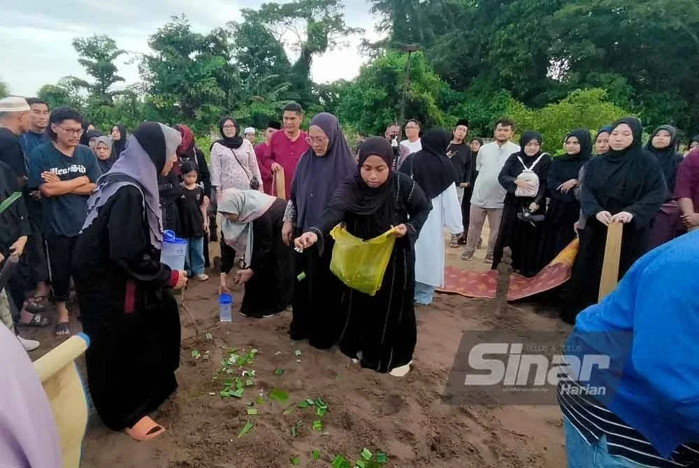 Ahli keluarga menabur bunga di pusara Allahyarham Mustaqqeem selepas selesai proses pengebumian.