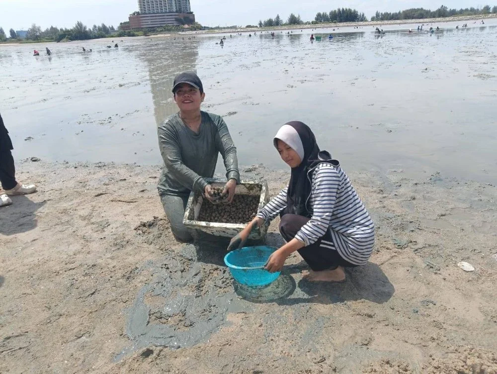 Roszana bersama anak saudaranya menunjukkan lebih dua kilogram kerang hidup yang berjaya dicari dalam kawasan berselut itu.