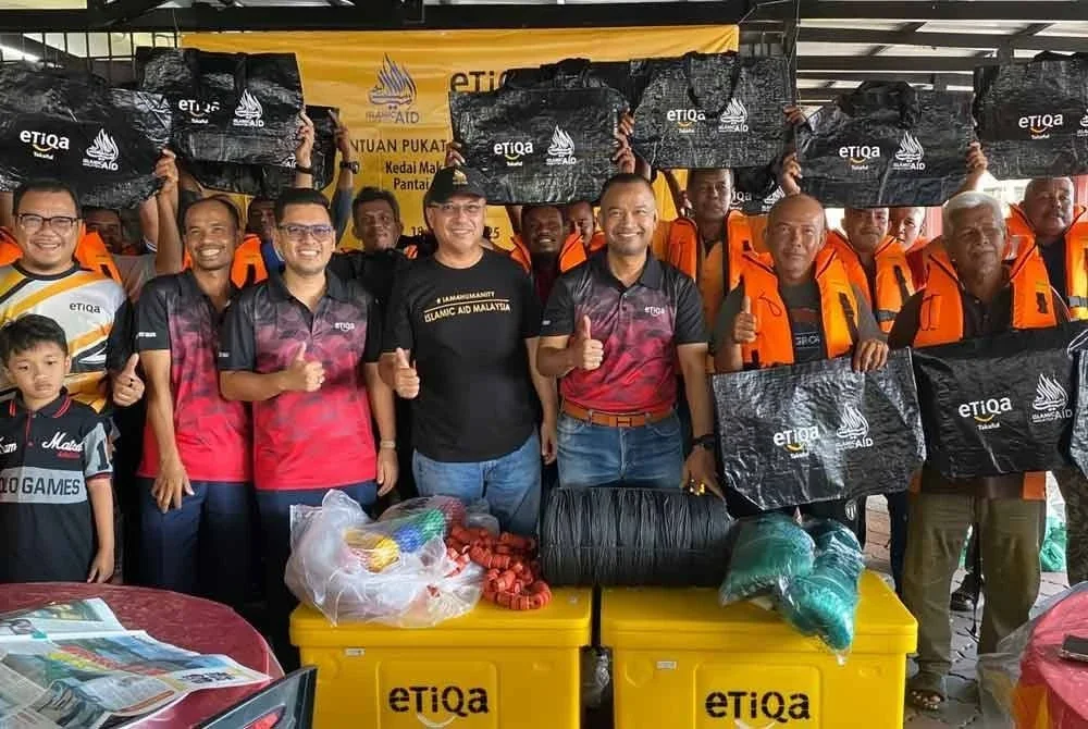 Zawahir (empat,kiri) dan Muhammad Nurawi (tiga,kanan) semasa penyampaian pukat, tong ikan serta jaket keselamatan kepada 25 nelayan di Pantai Geting, Tumpat pada Sabtu. Foto: SINAR HARIAN/HAZELEN LIANA KAMARUDIN