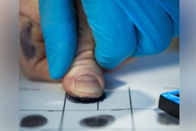 Suspek dilihat membuka beg mayat sebelum menekan jari Peng ke atas sekeping kertas menggunakan dakwat cap jari. Agensi