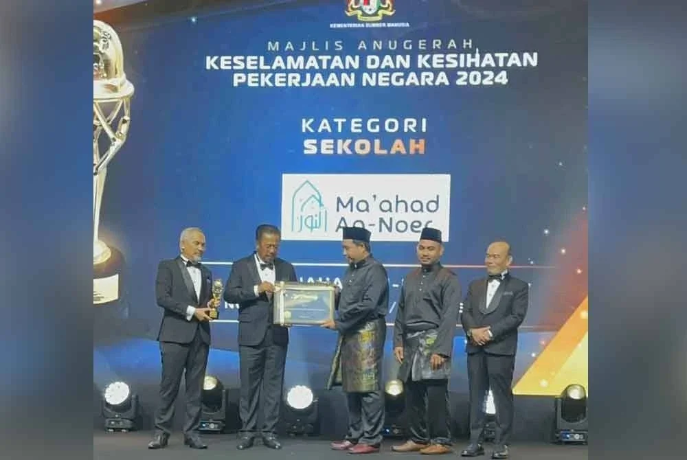 Hafiz (tiga dari kanan) menerima anugerah yang disampaikan oleh Timbalan Menteri Sumber Manusia, Datuk Seri Abdul Rahman Mohamad (dua dari kiri) di Bentong pada Sabtu.