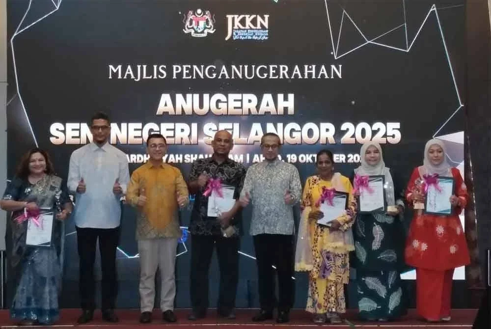 Borhan (tiga dari kiri) dan Mohd Amran (empat dari kanan) bergambar bersama penerima anugerah sempena Majlis Penganugerahan ASN 2025 di Shah Alam pada Ahad.