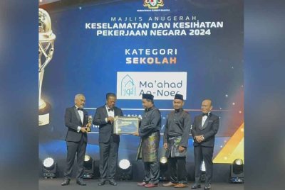 Hafiz (tiga dari kanan) menerima anugerah yang disampaikan oleh Timbalan Menteri Sumber Manusia, Datuk Seri Abdul Rahman Mohamad (dua dari kiri) di Bentong pada Sabtu.