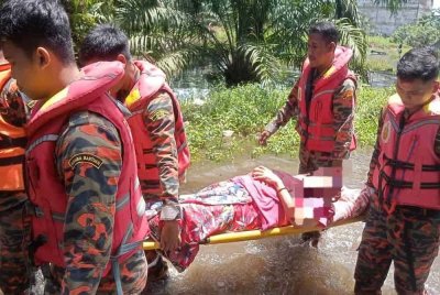 Anggota bomba menyelamatkan seorang wanita warga emas yang terperangkap dalam banjir di Kampung Bugis, Batu 6 Penerok, Pontian. - Foto JBPM Johor