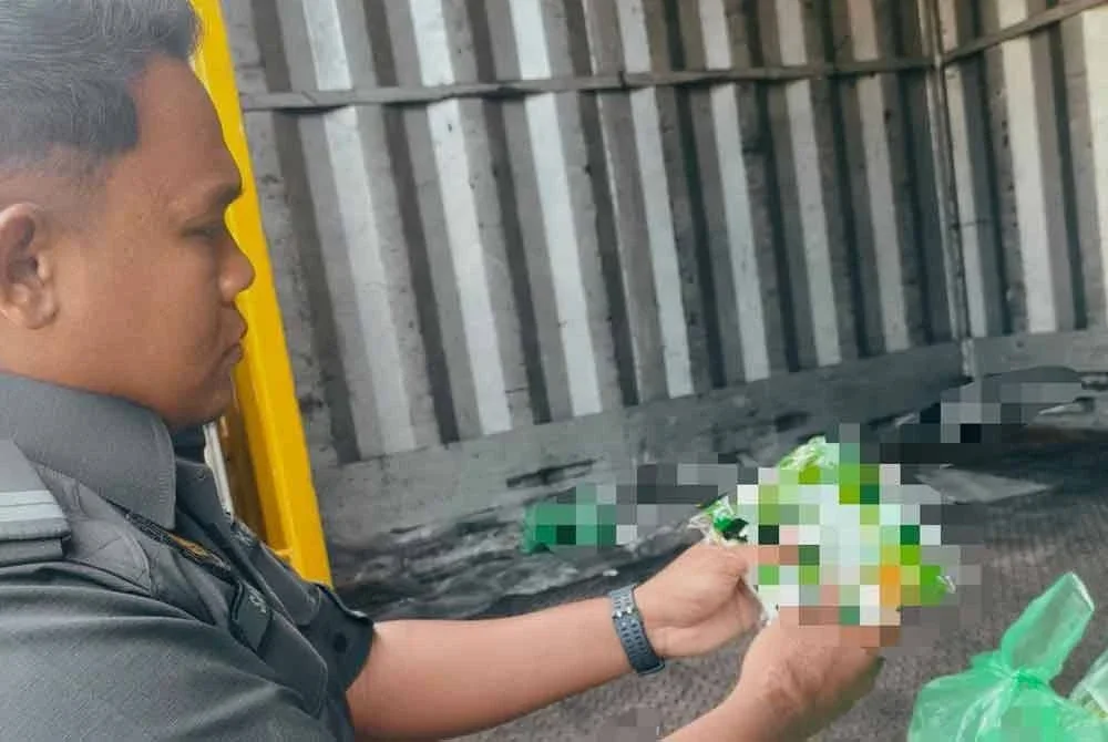 Anggota penguat kuasa meneliti logo halal JAKIM yang tertera pada pek pembungkusan dalam operasi bersepadu pada Ahad.