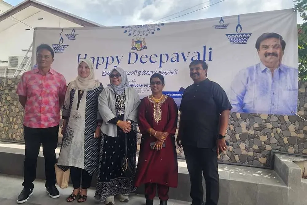 Dzulkhairi (dua dari kiri) dan isteri, Datin Diana Aini Mokter (dua,kiri) bergambar bersama Shanmugam (kanan) pada majlis rumah terbuka berkenaan di Batu Berendam di sini pada Isnin.