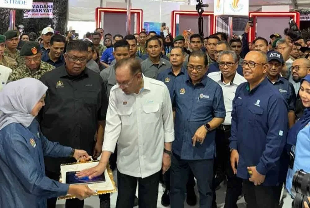 Anwar (tengah) yang diiringi Mohamed Khaled, menyempurnakan pelancaran rasmi KELIO – Madu Kelulut Multiflora sempena Program Madani Rakyat 2025 Zon Selatan di Politeknik Merlimau, Melaka.