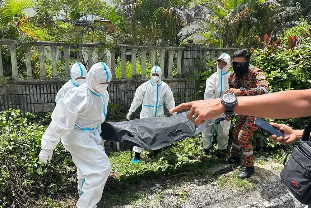 Anggota bomba mengangkat mayat yang ditemui di dalam longkang.