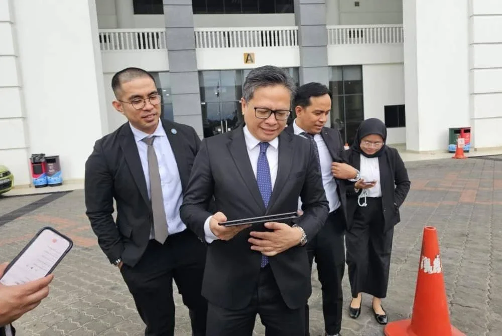 Rizwandean bersama rakan sepasukannya ketika di pekarangan Kompleks Mahkamah Kota Kinabalu.