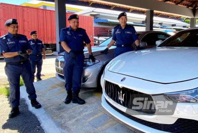 Wan Jamal Abdul Salam (kanan) menunjukkan antara kenderaan mewah yang berjaya dirampas oleh JKDM Kelantan semasa sidang akhbar di Pejabat JKDM Kelantan, Kota Bharu pada Selasa.