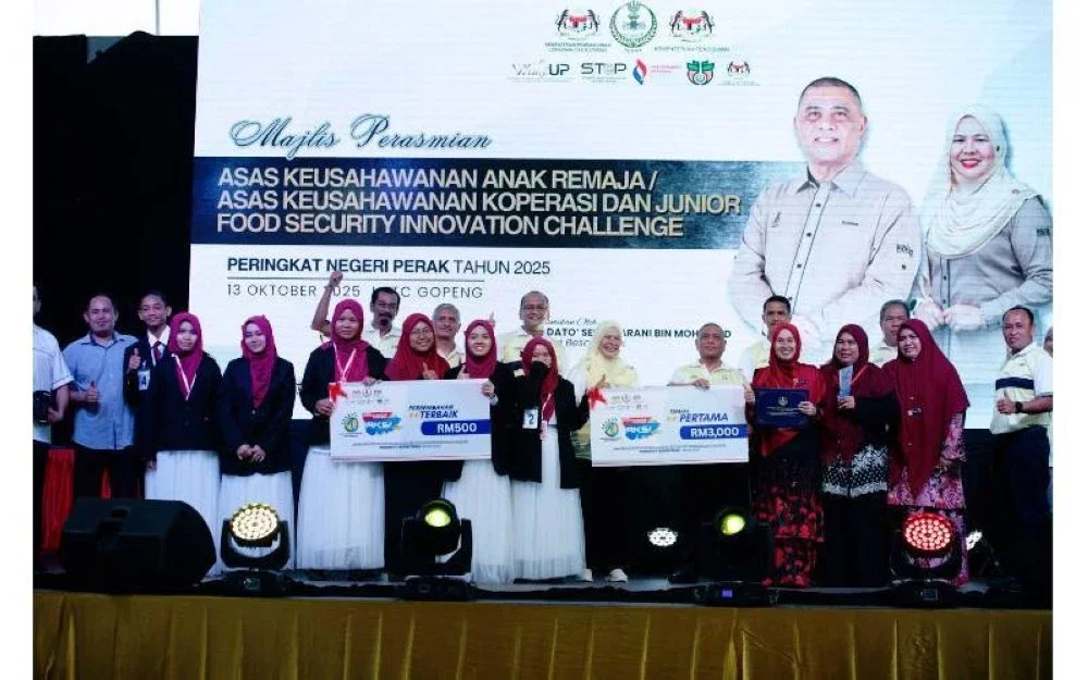  Saarani (hadapan, empat dari kanan) menyampaikan hadiah kepada Koperasi SMK Rungkup selepas dinobatkan sebagai johan sempena Pertandingan AKAR dan AKSI Peringkat Negeri Perak 2025 di RTC Perak di sini baru-baru ini.