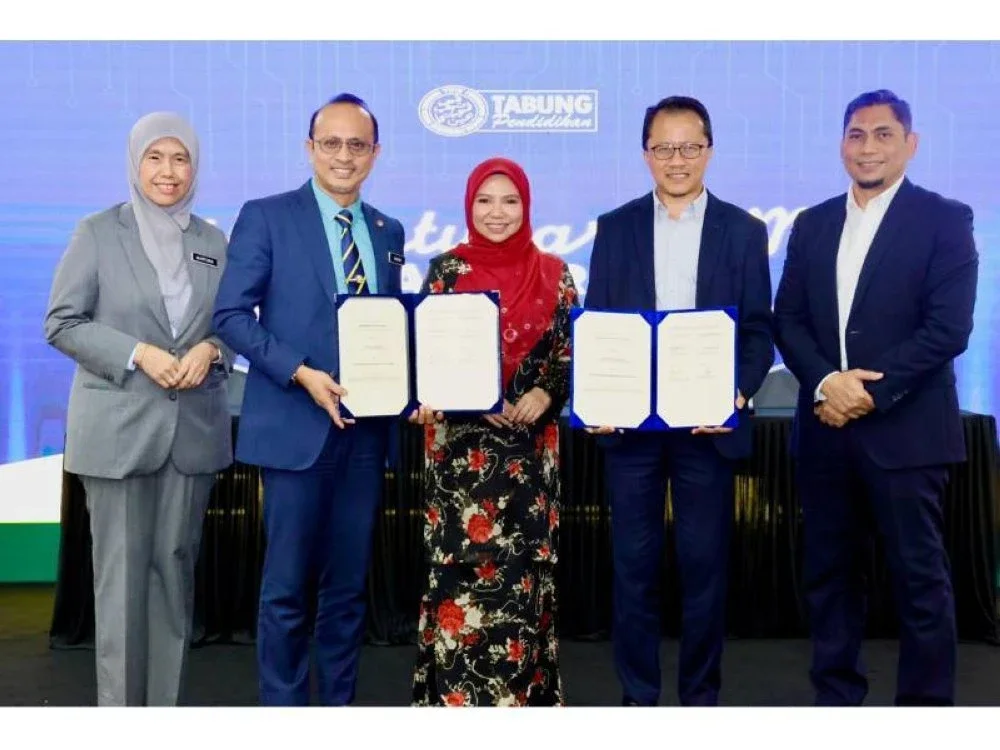 Pertukaran MoU antara Ahmad Dasuki (dua dari kiri) dan Nik Hisham (dua dari kanan) dengan disaksikan oleh Norliza.