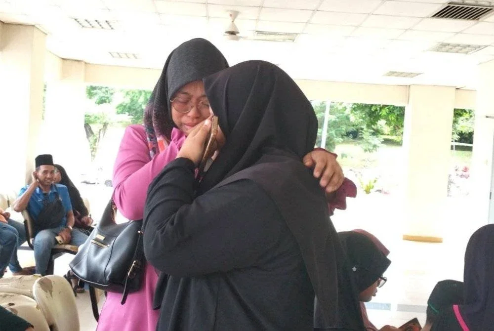 Norazmirah (kiri) tidak dapat menahan sebak ketika berada di Unit Forensik Hospital Sultan Ismail, Johor Bahru.