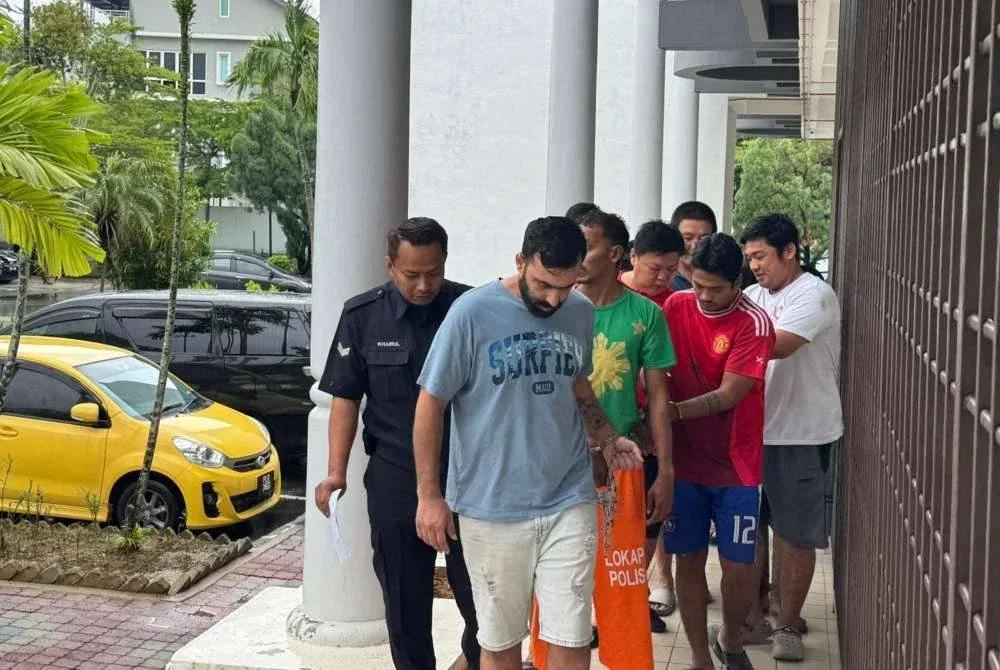 Tertuduh ketika diiringi polis ke mahkamah pada Rabu.