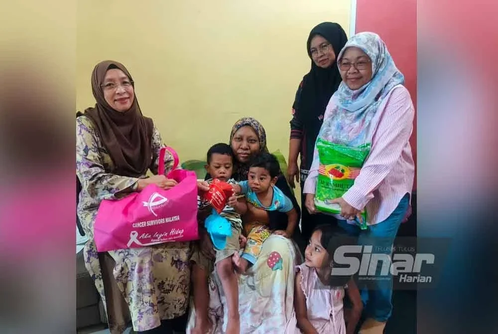 Zuraini (kiri) menyampaikan sumbangan CSM kepada Nor Artiqah semasa menziarahinya di Taman PKNK di Alor Setar pada Rabu.