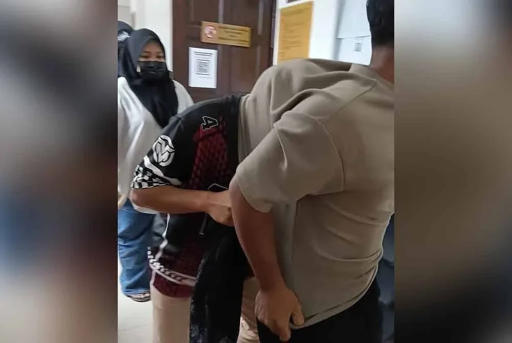 Meor Aliff Isqandar (tengah) dibawa keluar dari Mahkamah Tinggi Syariah Melaka selepas hukuman dijatuhkan.