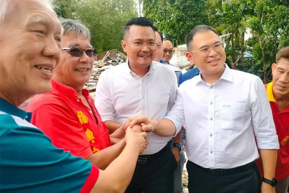 Meng Seng (dua kiri) bersalaman dengan Hairi (dua kanan), Tian Soon (kanan) yang melawat Kampung Cina Kebun Teh pada Rabu susulan keputusan kerajaan Johor memberi lanjutan tempoh kepada penduduk setinggan untuk mengosongkan rumah mereka.