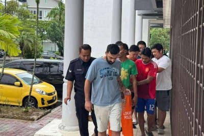 Tertuduh ketika diiringi polis ke mahkamah pada Rabu.